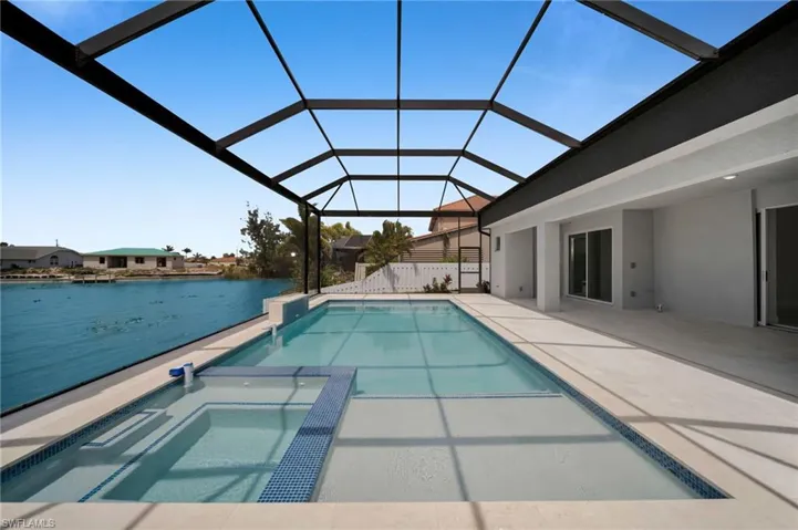 View of pool featuring a patio, a lanai, and a pool with connected hot tub