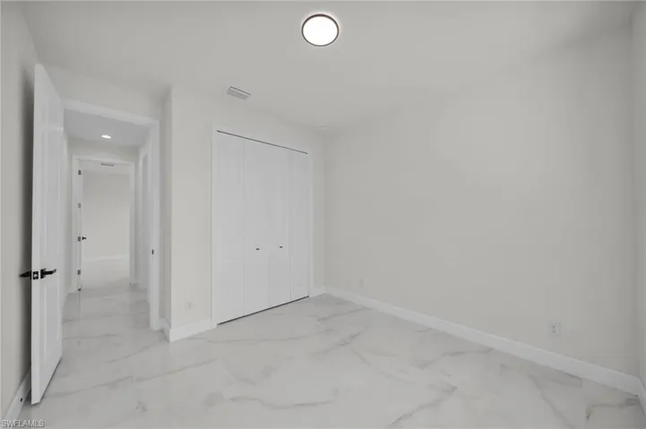 Unfurnished bedroom with baseboards, visible vents, a closet, and marble finish floor