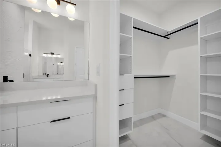 Spacious closet featuring marble finish floor