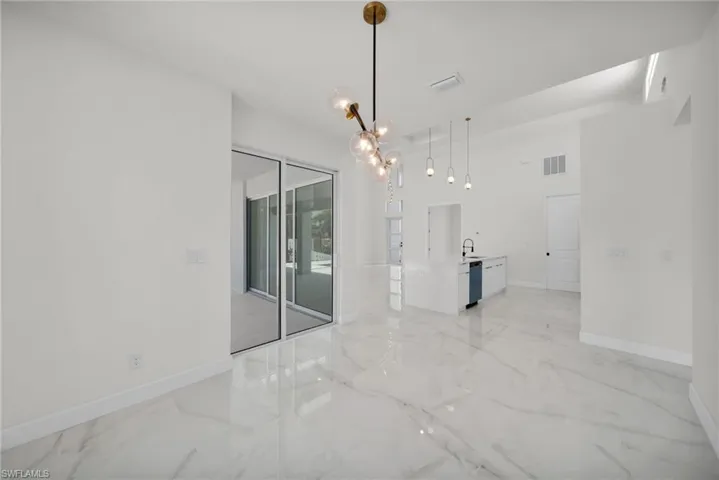 Empty room featuring visible vents, marble finish floor, and baseboards