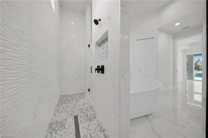 Full bath with recessed lighting, a marble finish shower, a freestanding bath, and marble finish floor