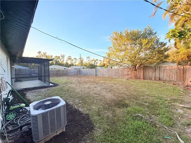 Fenced backyard with a sunroom and a patio area