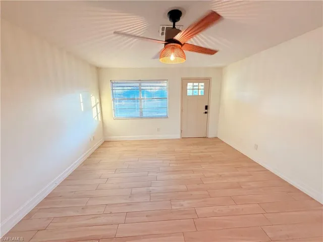 Empty room with light wood finished floors and a ceiling fan