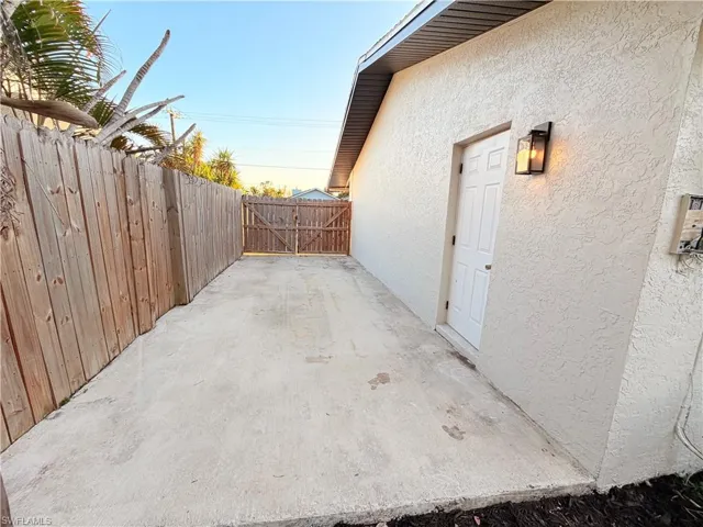 Fenced backyard featuring a patio area and a gate