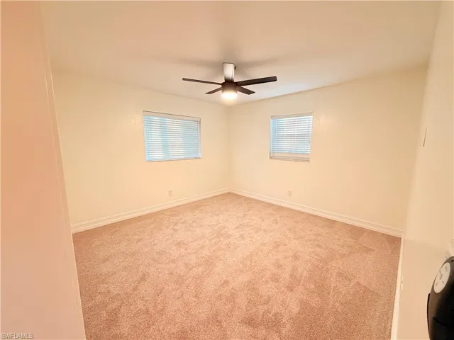 Empty room with healthy amount of natural light and light colored carpet