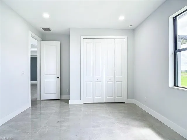 Unfurnished bedroom with a closet and light tile floors