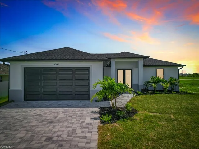 View of front of home featuring a garage and a lawn