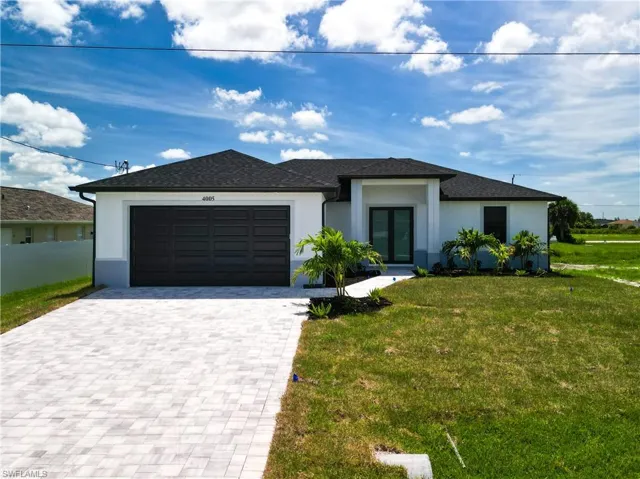 View of front of property featuring a garage and a front yard