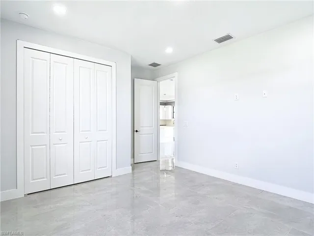 Unfurnished bedroom with a closet and light tile flooring