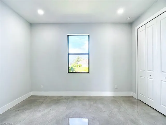 Unfurnished bedroom with a closet and light tile flooring