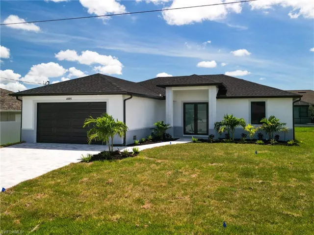 View of front of home with a garage and a front lawn