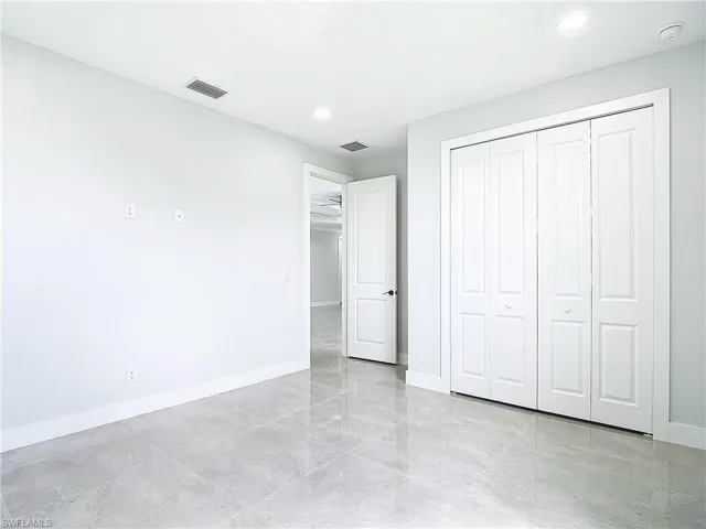 Unfurnished bedroom with a closet and light tile floors