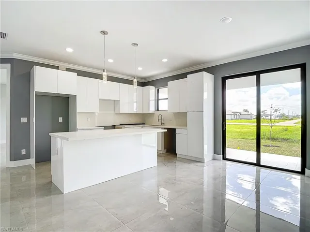 Kitchen featuring a wealth of natural light, white cabinets, and a center island