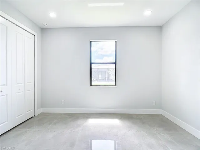 Unfurnished bedroom with a closet and light tile flooring