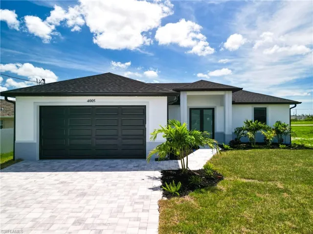 View of front facade featuring a front yard and a garage