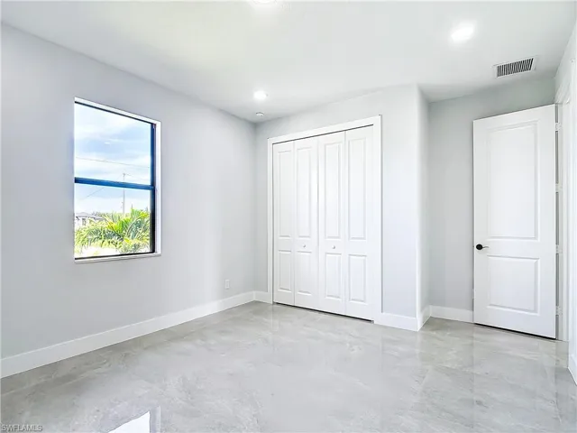 Unfurnished bedroom with a closet and light tile flooring