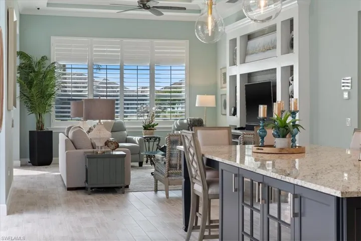 Living area with light wood-style floors and a ceiling fan