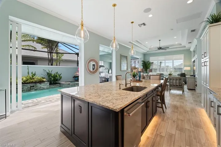 Kitchen featuring visible vents, dishwasher, a tray ceiling, crown molding, and a sink