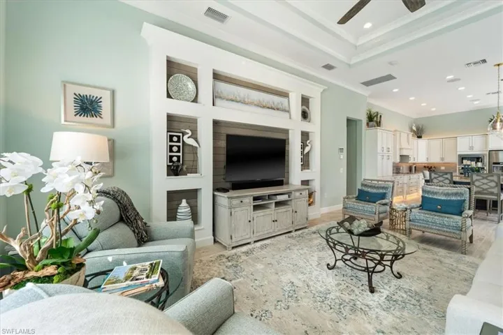 Living area featuring ornamental molding, visible vents, and light wood finished floors