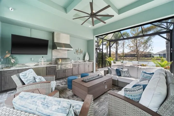 Living area featuring a sunroom, coffered ceiling, a ceiling fan, and beamed ceiling