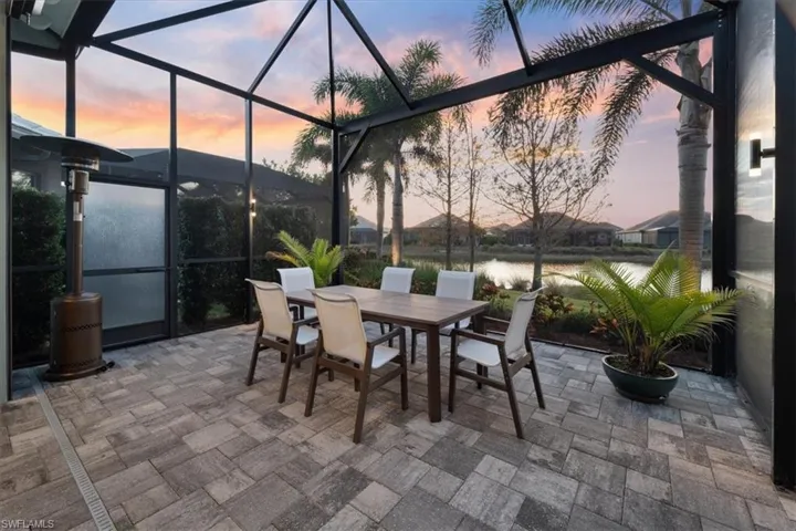 Patio terrace at dusk featuring a lanai and outdoor dining area