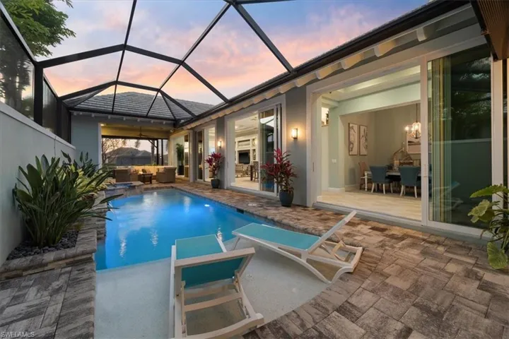 View of swimming pool featuring a pool with connected hot tub, a patio area, and an outdoor living space