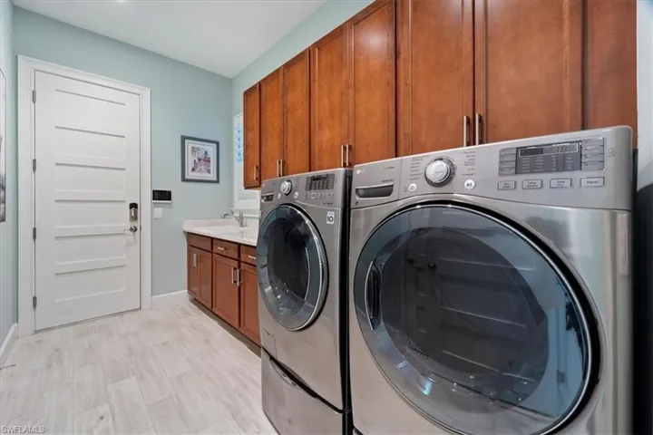 Laundry room featuring cabinet space, baseboards, and separate washer and dryer