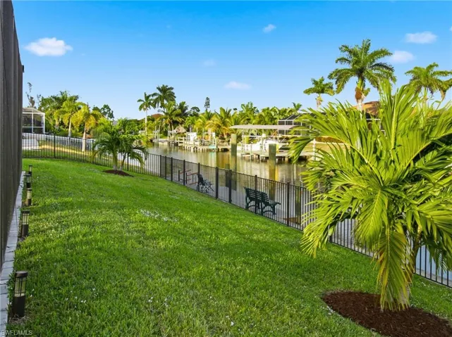 Fenced backyard featuring a water view