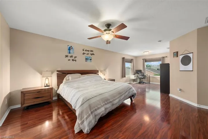 Primary Bedroom with wood-type flooring, a ceiling fan, and plenty of windows with natural light