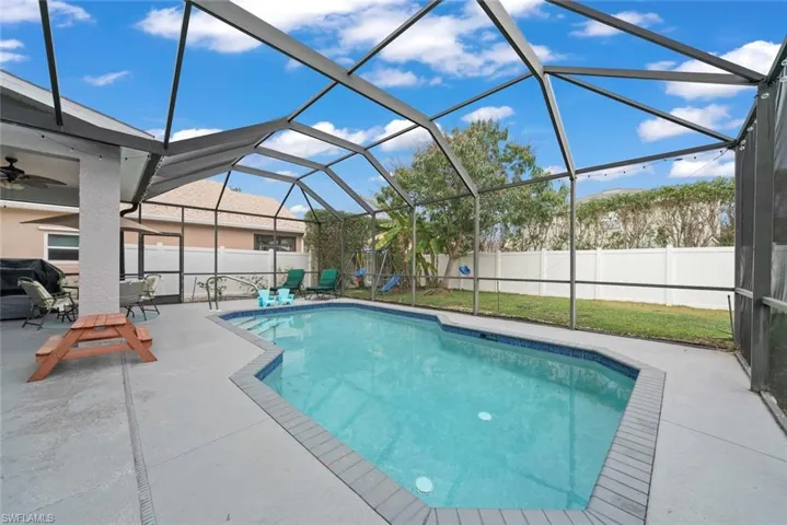 View of pool with patio and screened enclosure, outdoor dining space, and a fenced backyard