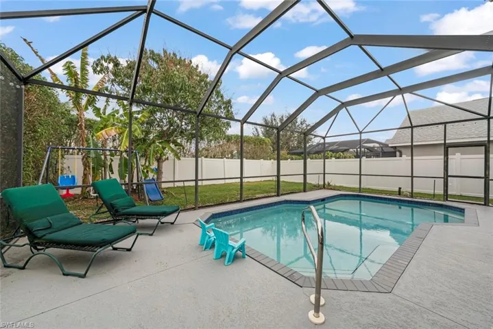 View of swimming pool featuring a lanai and fenced backyard