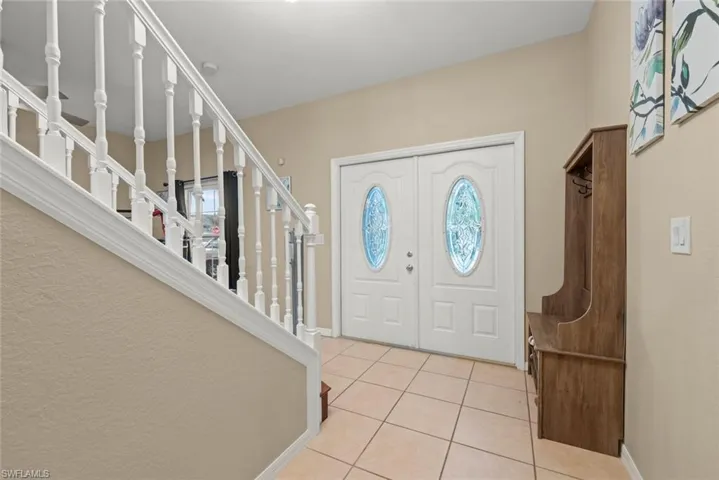 Foyer entrance featuring light tile patterned floors and plenty of natural light