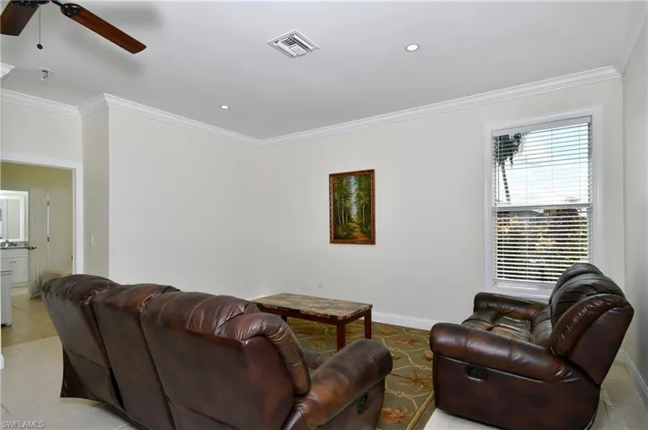 Living area with crown molding, a ceiling fan, light tile patterned flooring, and recessed lighting