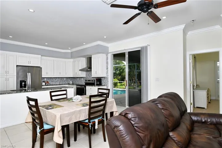Dining room with ceiling fan, crown molding, light tile patterned floors, and recessed lighting