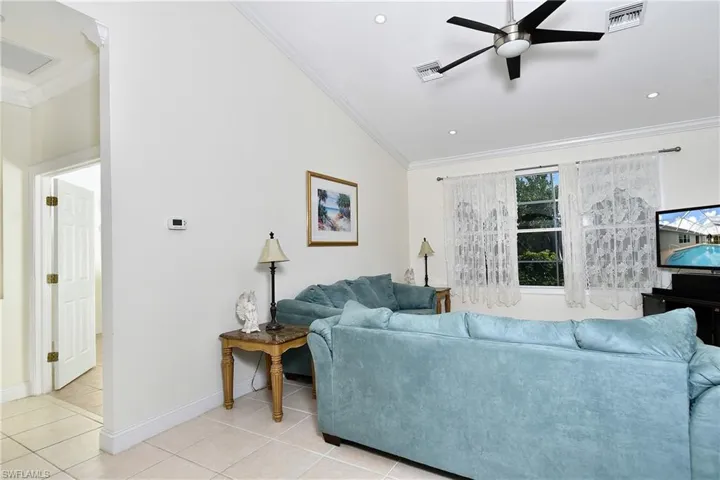 Living room featuring crown molding, a ceiling fan, light tile patterned flooring, and recessed lighting