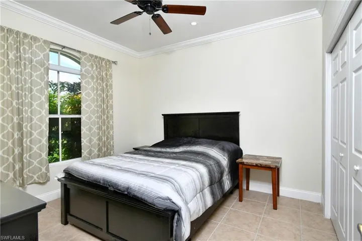 Bedroom with crown molding, a closet, light tile patterned flooring, ceiling fan, and recessed lighting