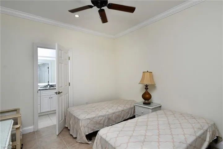 Bedroom featuring ornamental molding, light tile patterned floors, connected bathroom, recessed lighting, and a ceiling fan