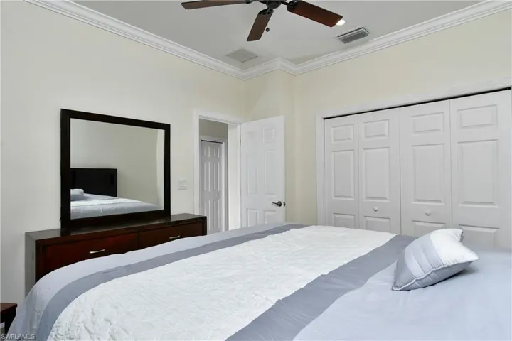 Bedroom with ornamental molding, a closet, and ceiling fan