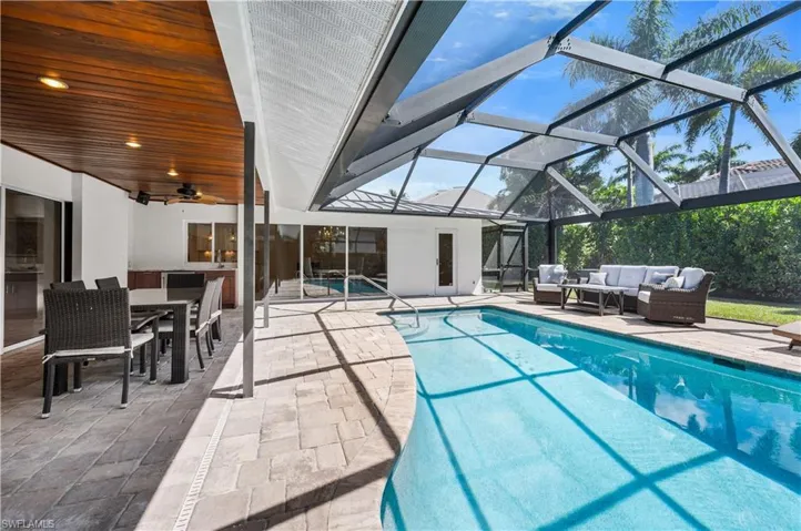 Swimming pool with outdoor dining space, a lanai, a patio, a sunroom, and an outdoor hangout area