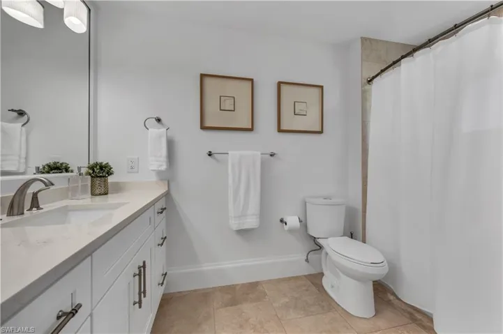Bathroom with vanity, a shower with curtain, and light tile patterned floors