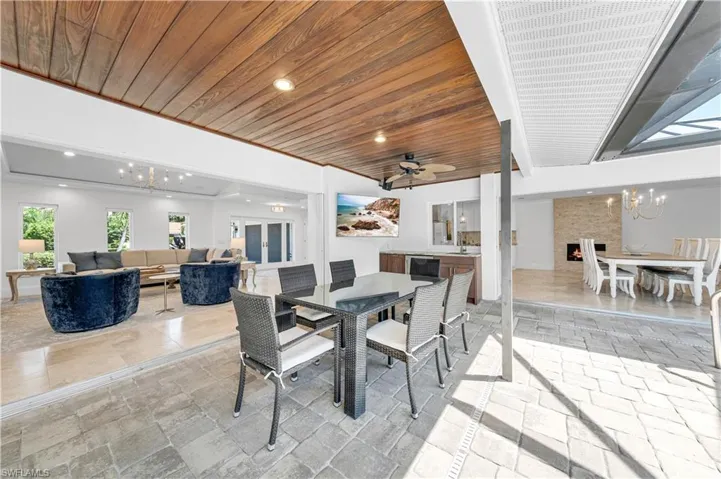 Dining area featuring a chandelier, recessed lighting, wood ceiling, a ceiling fan, and stone tile flooring