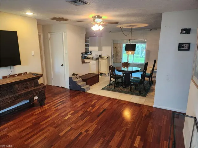 Dining area with light wood-style floors, a ceiling fan, and a textured ceiling