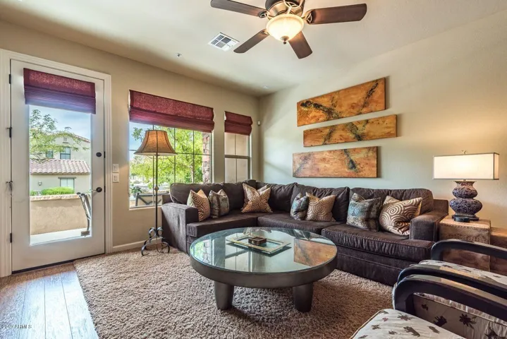 Living room with comfortable sectional and chairs, large patio with bbq