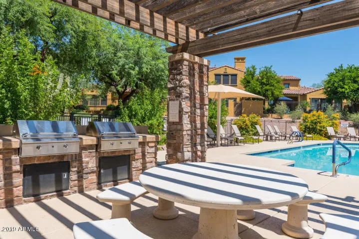 covered bbq area and tables by the pool