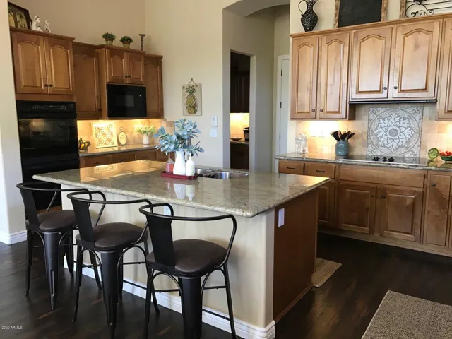 Kitchen with Electric Cooktop, Wall Ovens and Large Island with Seating Area.