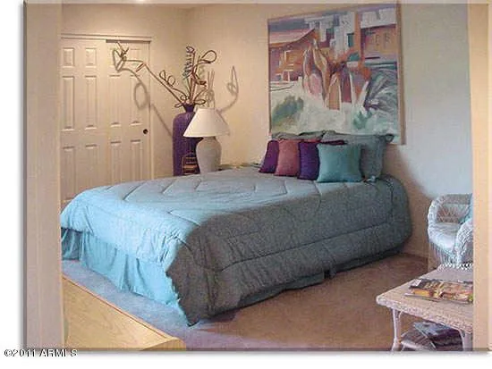 Bedroom with queen bed plus chair for reading or watching flat-screen TV