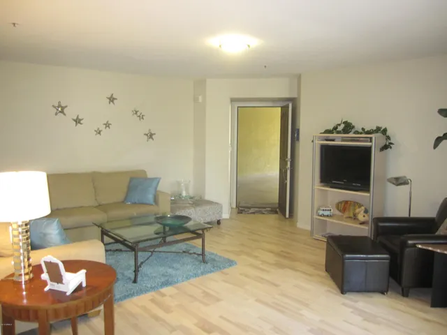 View to front entry, flat-screen TV and leather chair and ottoman.