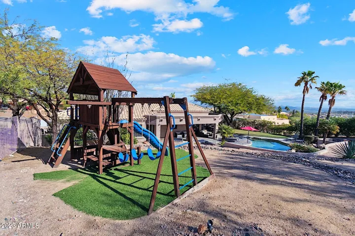 Playground for the kids with a wooden jungle gym / swing set.