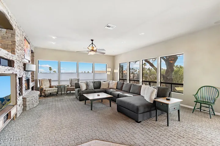 Living room w/ cozy fireplace, 65" Smart TV, and a large sectional sofa.