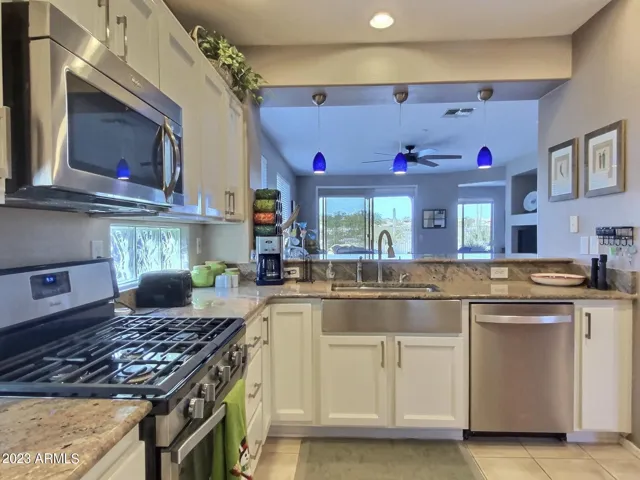 Kitchen Featuring a Stainless Gas Range and Deep Farm-Style Stainless Steel Sink